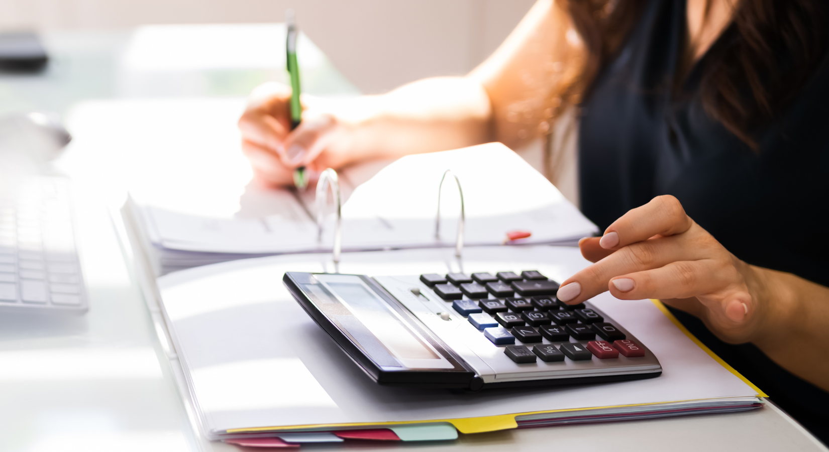 office worker at a desk using a calculator