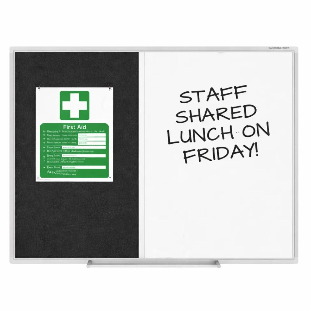 A whiteboard with a black left panel showing a green and white first aid sign, and a white right panel with handwritten text reading 'STAFF SHARED LUNCH ON FRIDAY!'.