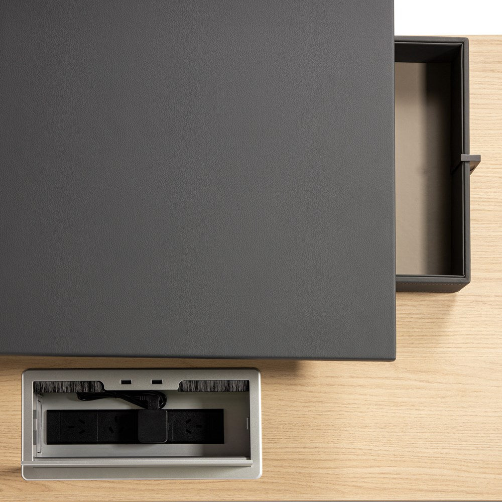 Black office desk with a drawer open on a wooden surface