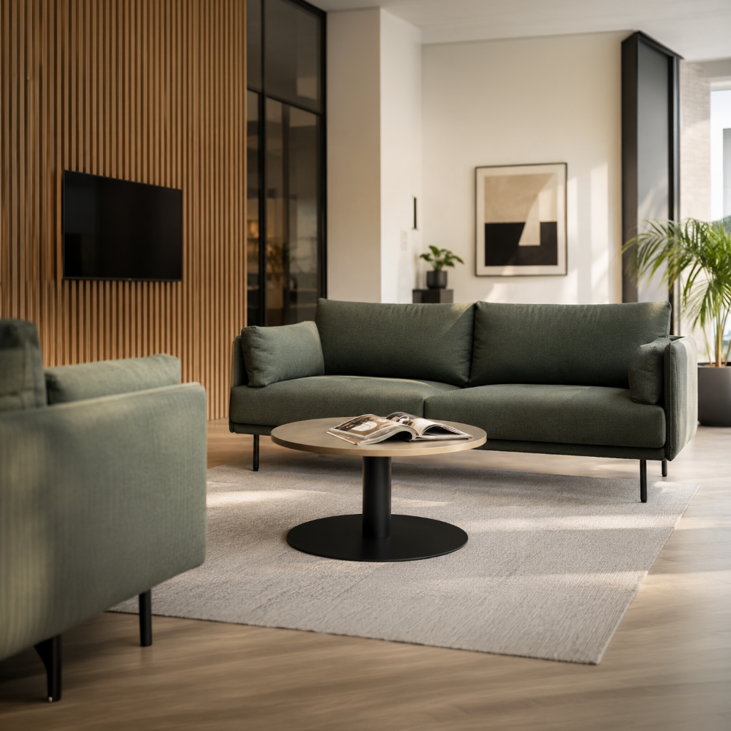 A modern living room featuring a dark green three-seater sofa, a matching armchair, a round coffee table, and a light-colored rug on a wood floor, set against a wall with vertical wood slats.