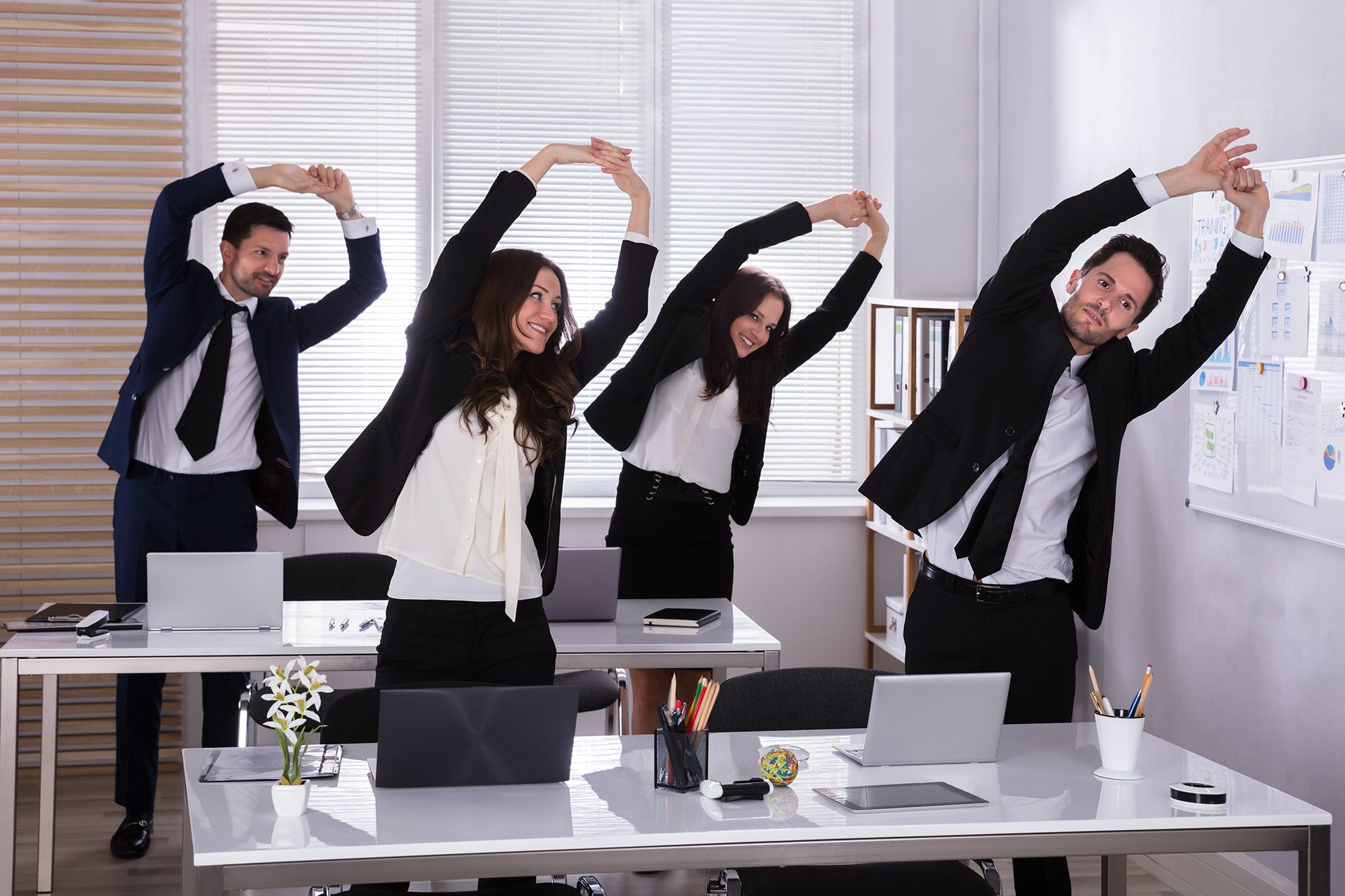 business people exercising behind desks