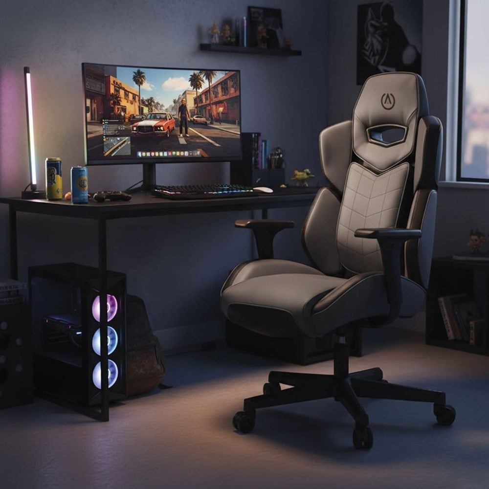 Gaming setup with a chair, desk, and computer monitor in a dimly lit room.