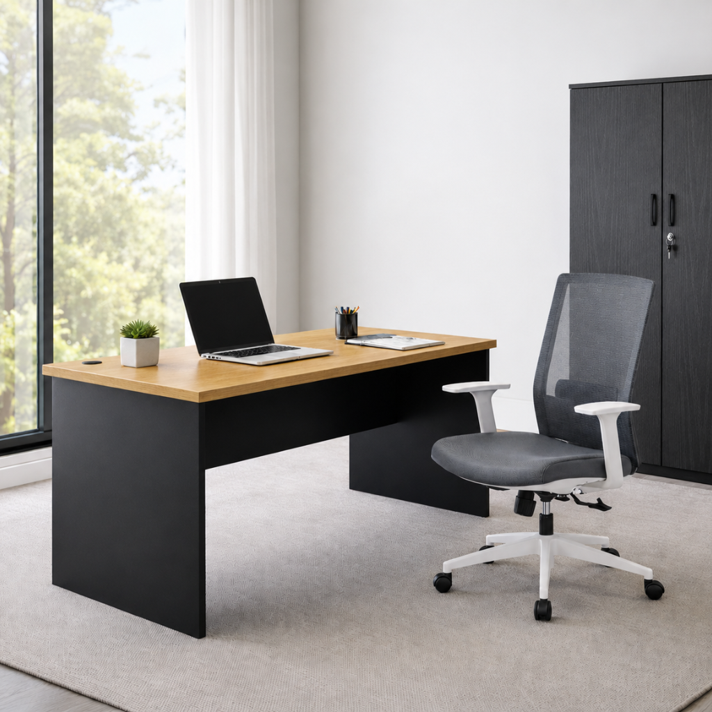 A modern home office setup featuring a black desk with a light wood top, a grey mesh office chair, and a dark wood cabinet in a bright room with a large window.