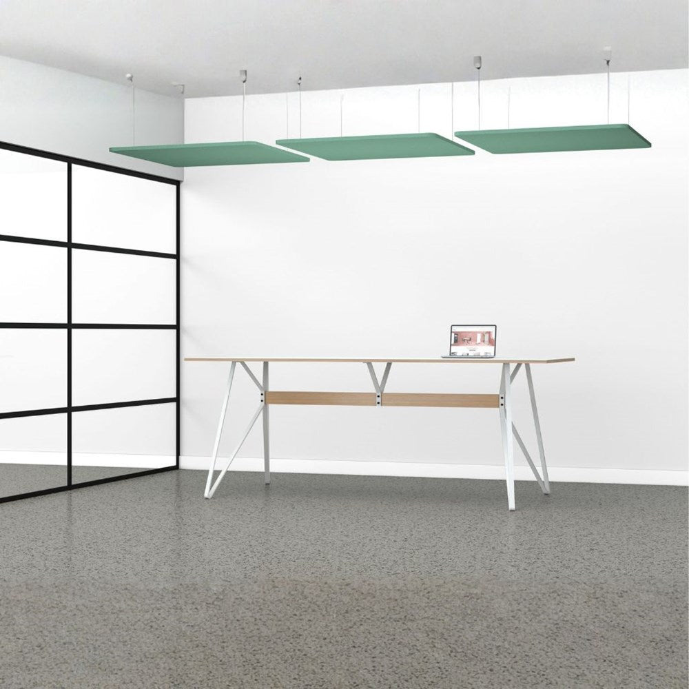 Modern office setup with a desk and green ceiling panels in a minimalistic room.