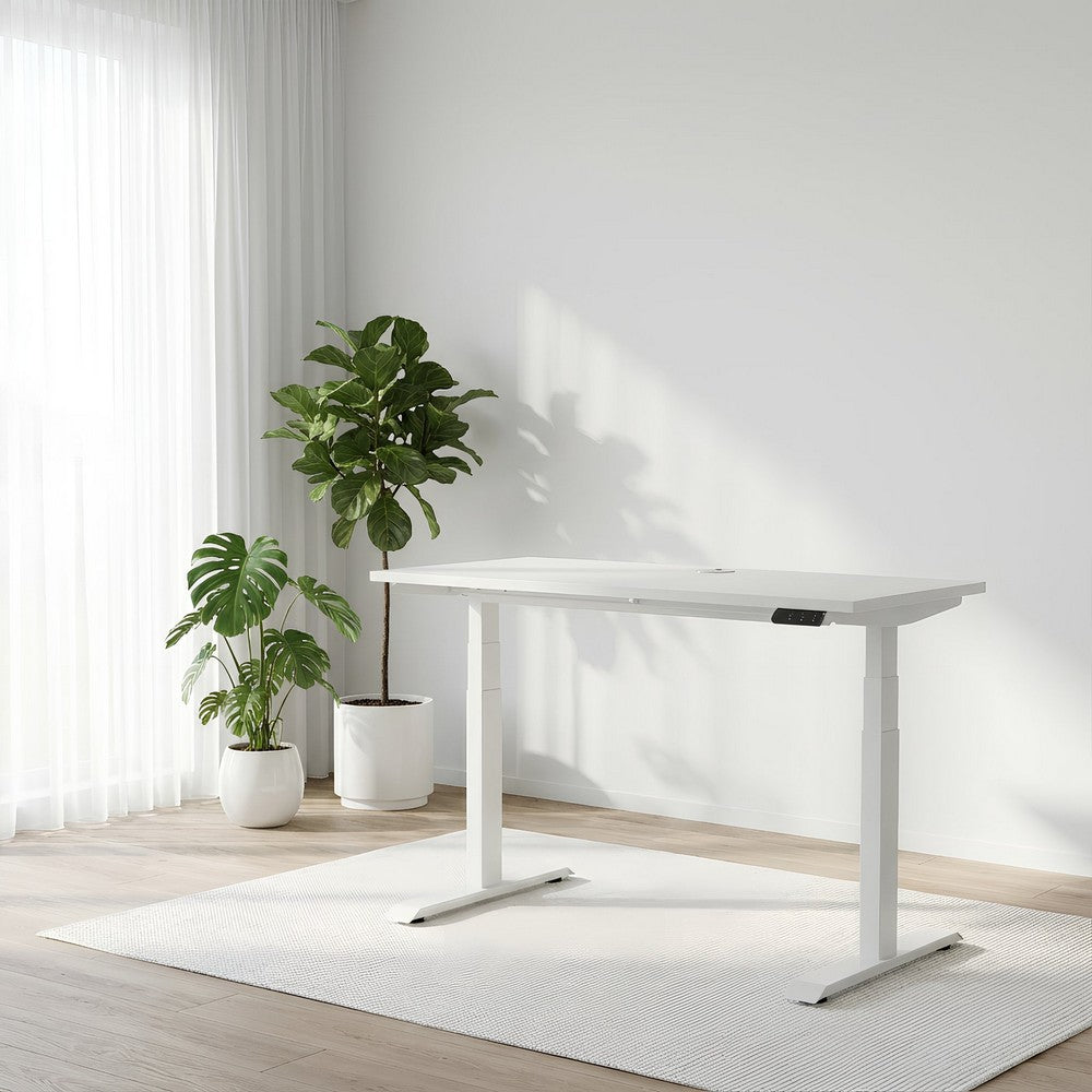 White adjustable desk in a room with plants and light-colored walls