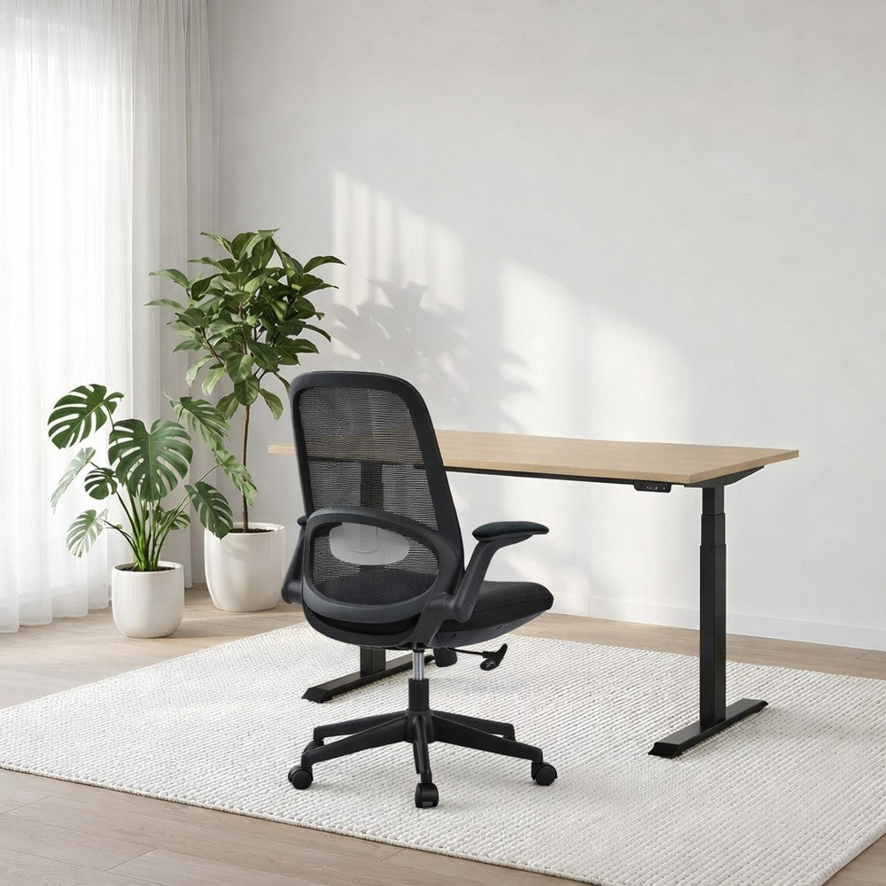 Black office chair in front of a wooden desk with plants in a room.