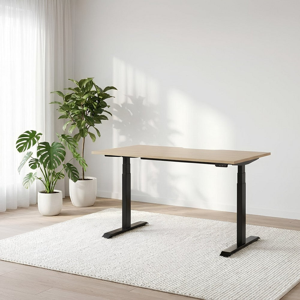 Wooden desk with black legs in a room with plants and a rug