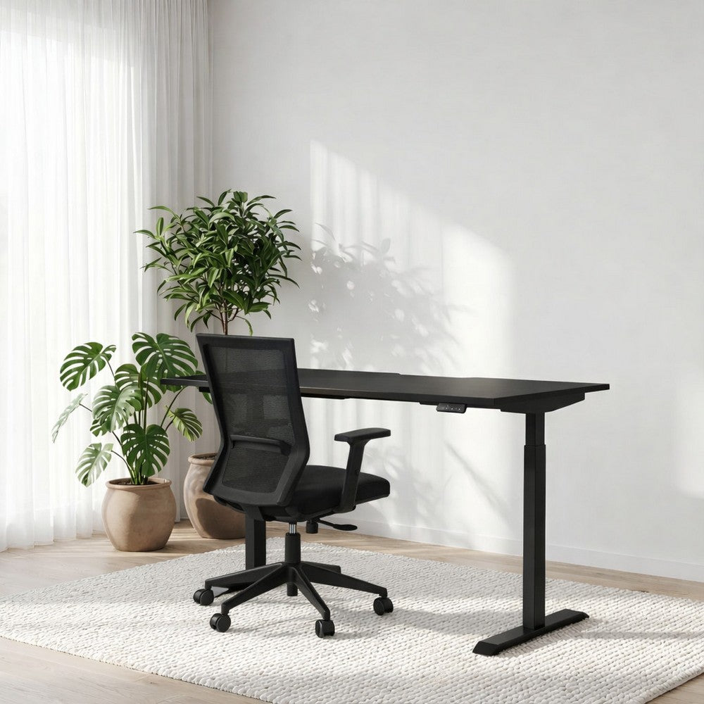 Black adjustable desk with a black office chair in a room with plants and white walls.