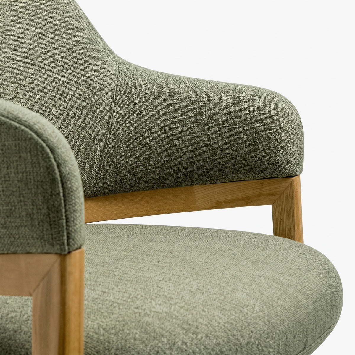 close up detail shot of sage colour armchair with wooden legs